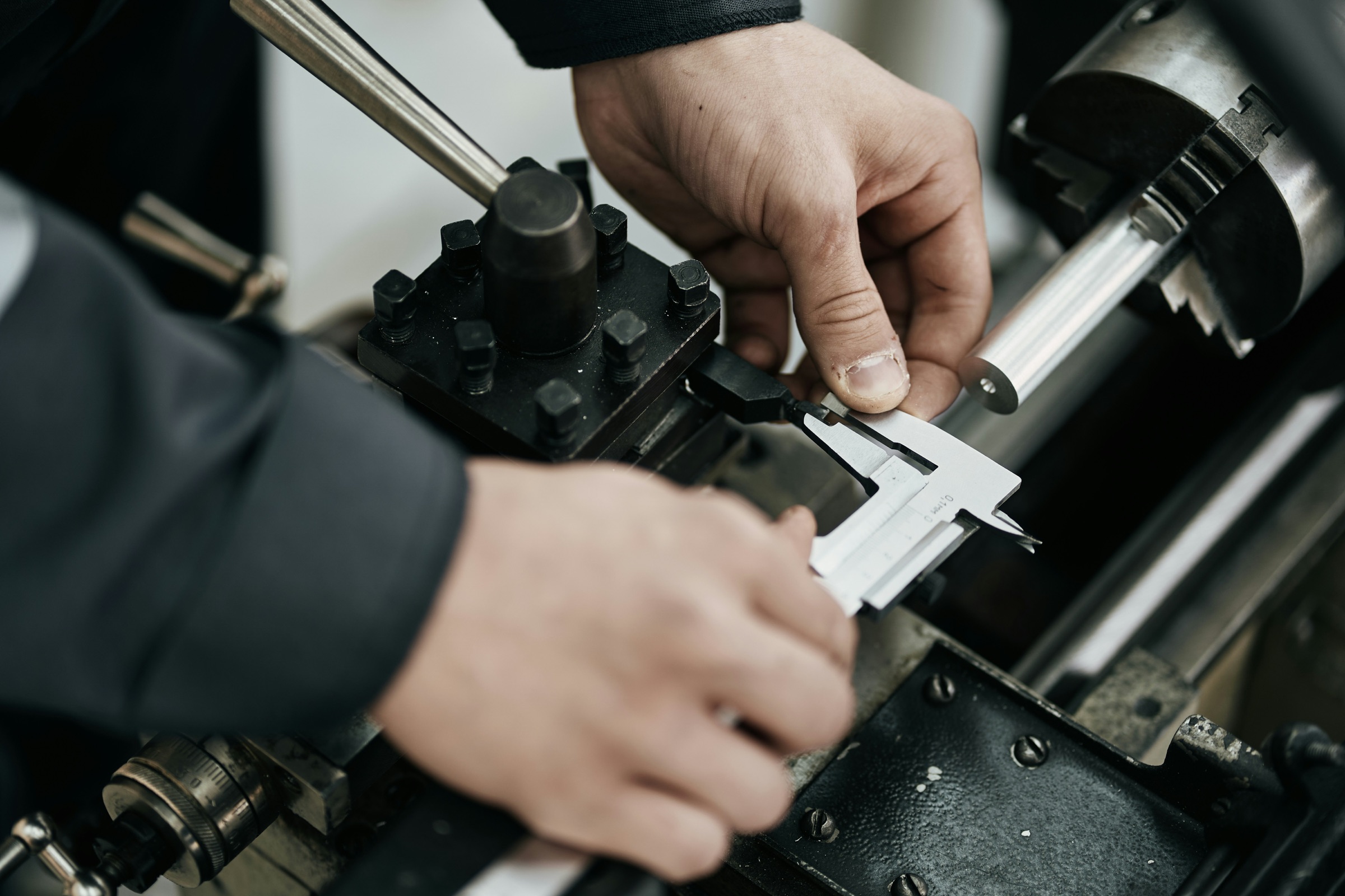 Engineer measuring a machined component with calipers